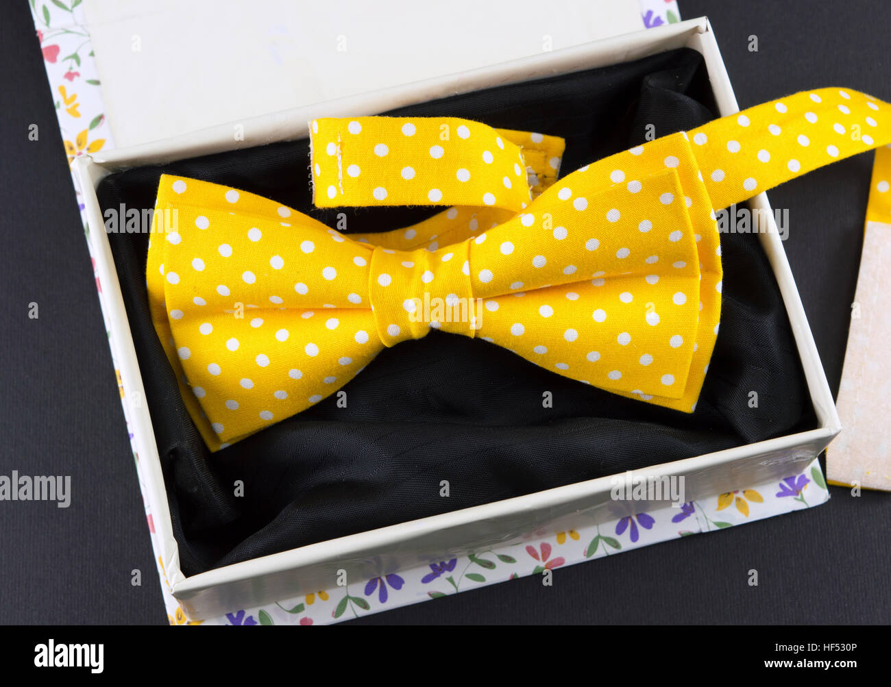 Gelben Fliege in einer Geschenkbox auf schwarzen Tisch Stockfoto