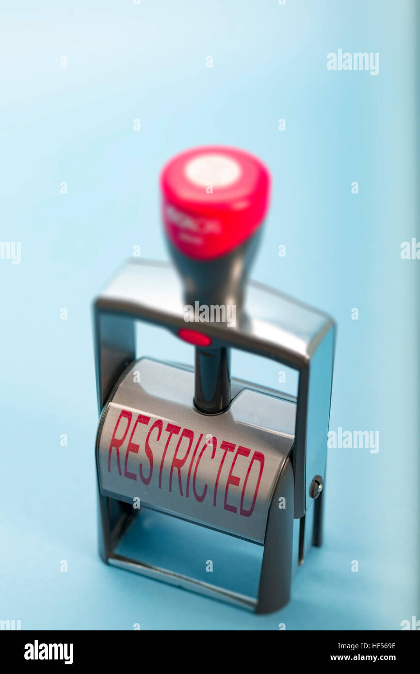 Handstempel mit dem Wort RESTRICTED in Großbuchstaben auf dem Etikett in roten Lettern Stockfoto