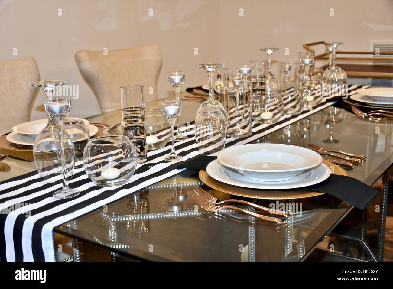 Ein elegantes Abendessen richten Sie auf einem schönen Glastisch für eine formelle Festessen vorbereitet Stockfoto