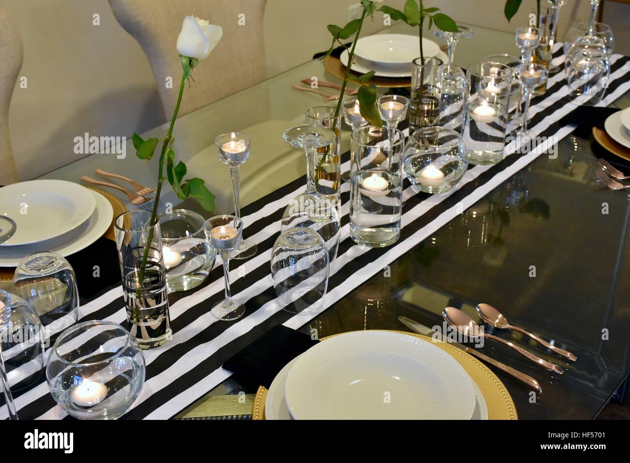 Ein elegantes Abendessen richten Sie auf einem schönen Glastisch für eine formelle Festessen vorbereitet Stockfoto