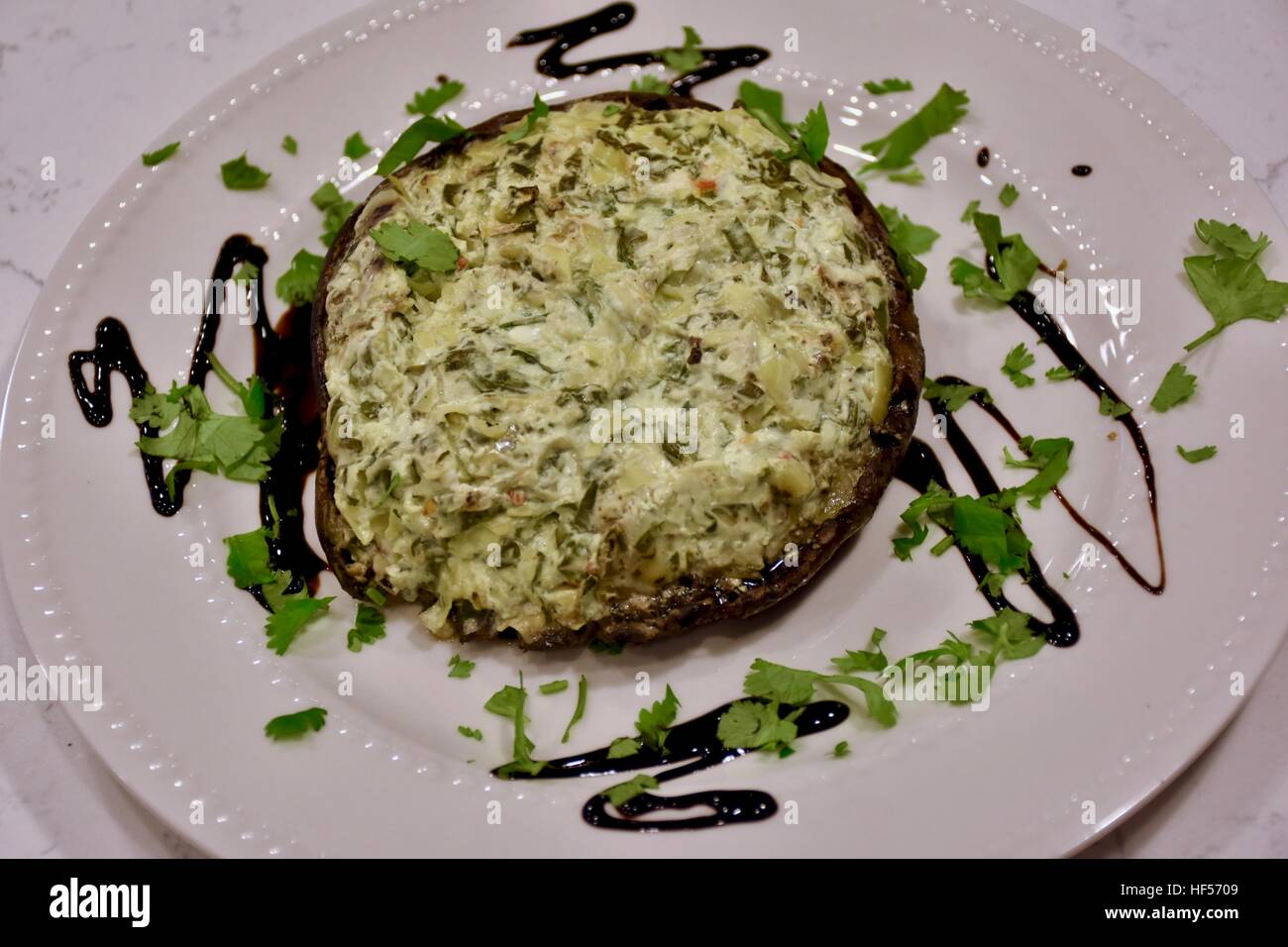 Eine gefüllte Portobello-Pilze angezeigt auf einem weißen Teller Stockfoto