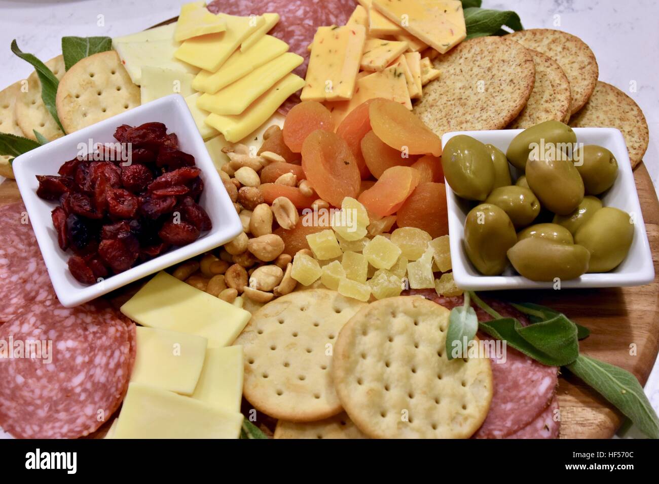 Ein Teller Essen vorbereiten für eine Weihnachtsfeier, bestehend aus Käse, Cracker, getrockneten Früchten, Nüssen und Oliven als Vorspeise Stockfoto
