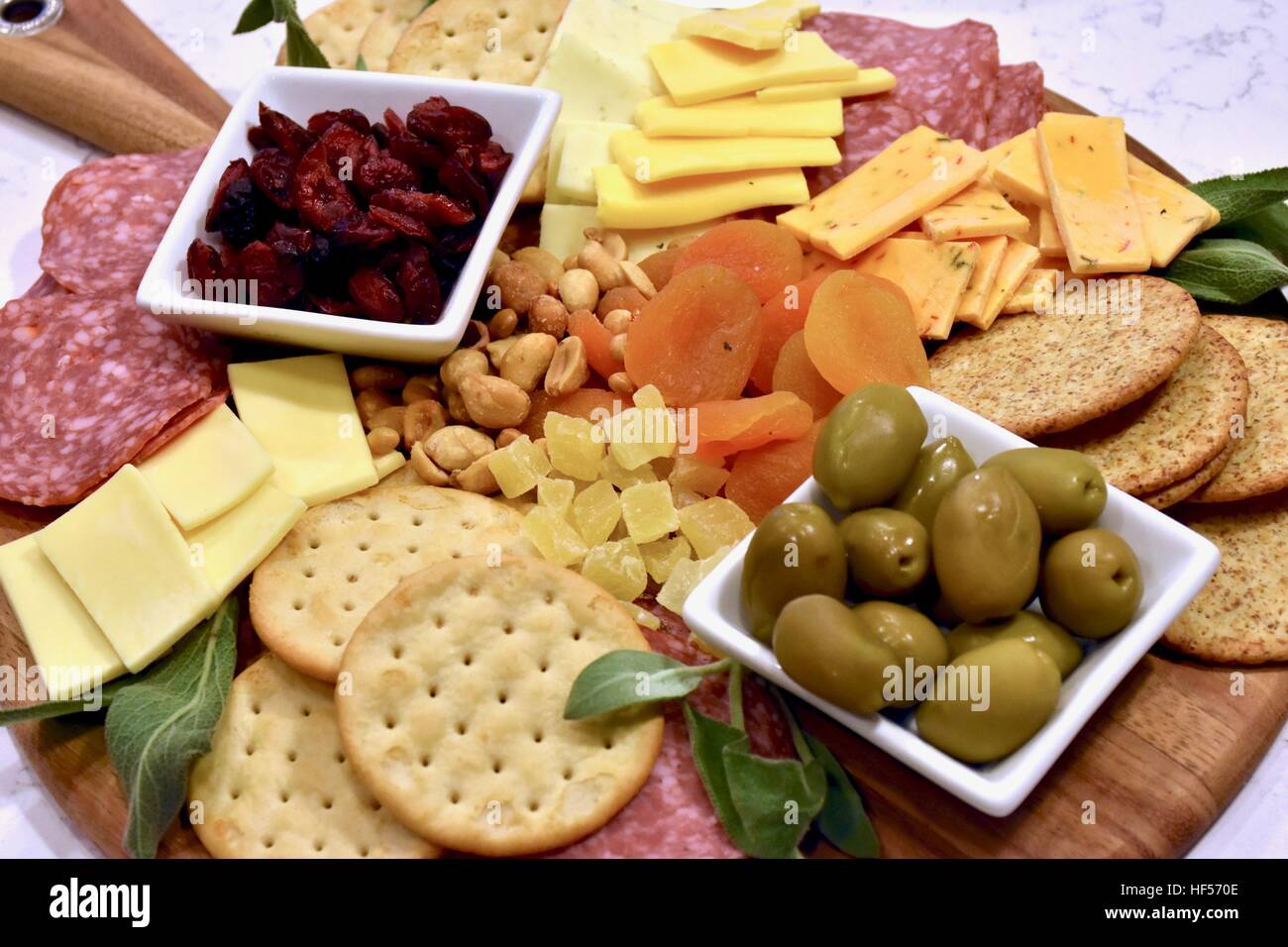 Ein Teller Essen vorbereiten für eine Weihnachtsfeier, bestehend aus Käse, Cracker, getrockneten Früchten, Nüssen und Oliven als Vorspeise Stockfoto
