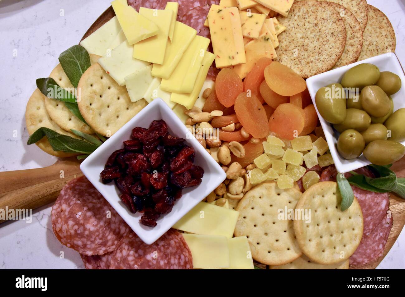 Ein Teller Essen vorbereiten für eine Weihnachtsfeier, bestehend aus Käse, Cracker, getrockneten Früchten, Nüssen und Oliven als Vorspeise Stockfoto