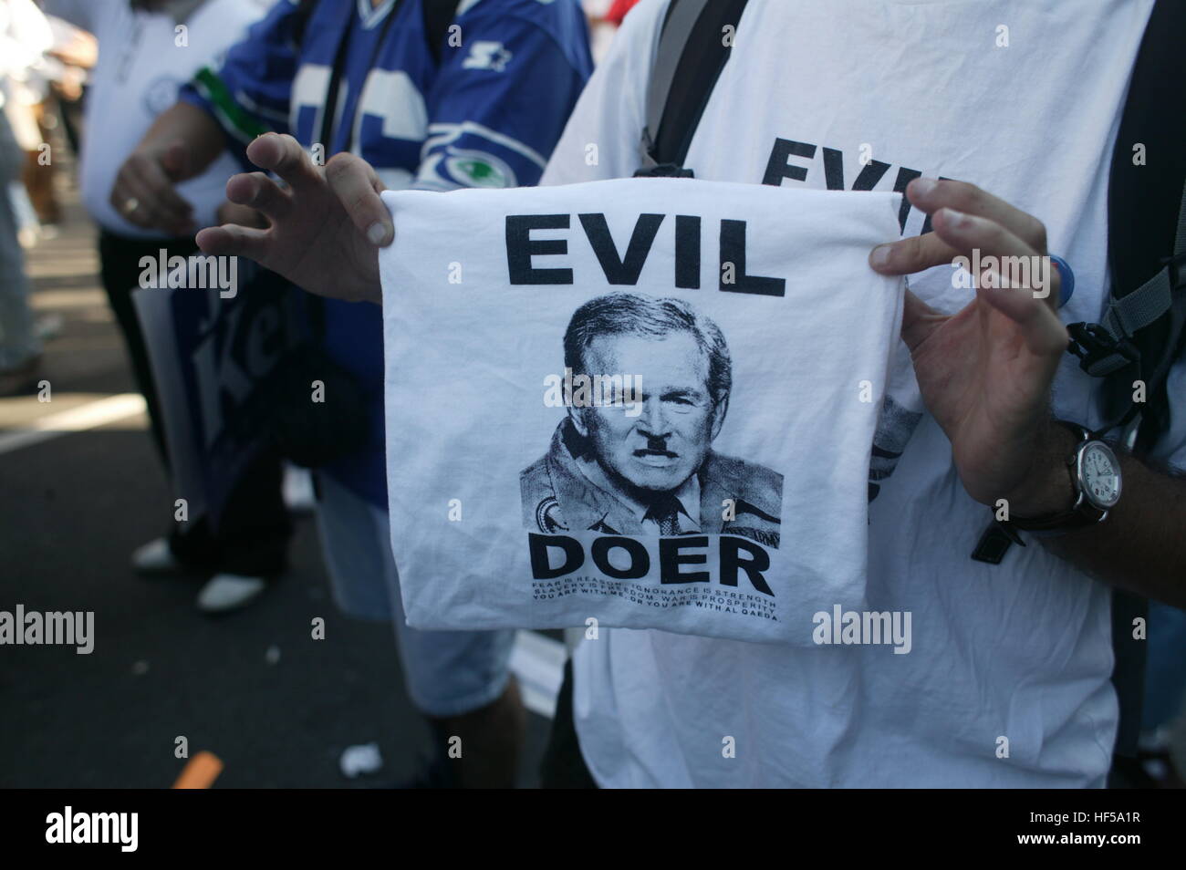 Ein Demonstrant hält ein Schild mit der Aufschrift "Böse handelnde," mit einem Bild von Bush mit Hitler Schnurrbart auf einen Protest bei der Republican National Convention 2004. Stockfoto