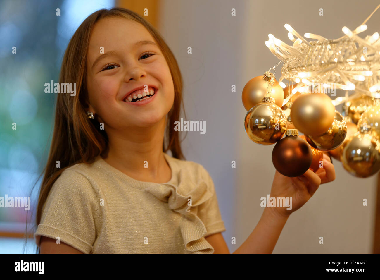 Junges Mädchen mit Beleuchtung und Kranz, Weihnachtsschmuck, Vorfreude auf Weihnachten, Upper Bavaria, Bavaria, Germany Stockfoto