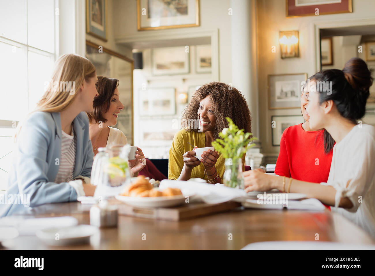 Lächelnde Frauen Kaffee trinken und reden am Tisch im restaurant Stockfoto