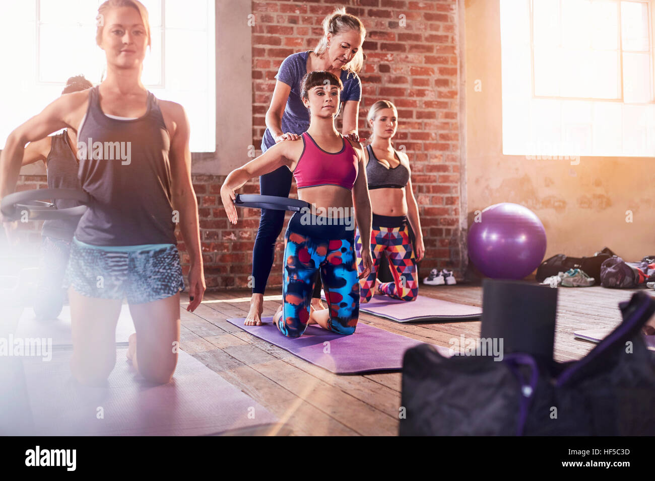 Fitness Instruktor helfende junge Frau mit Pilates Ring in Übung Klasse Gym studio Stockfoto