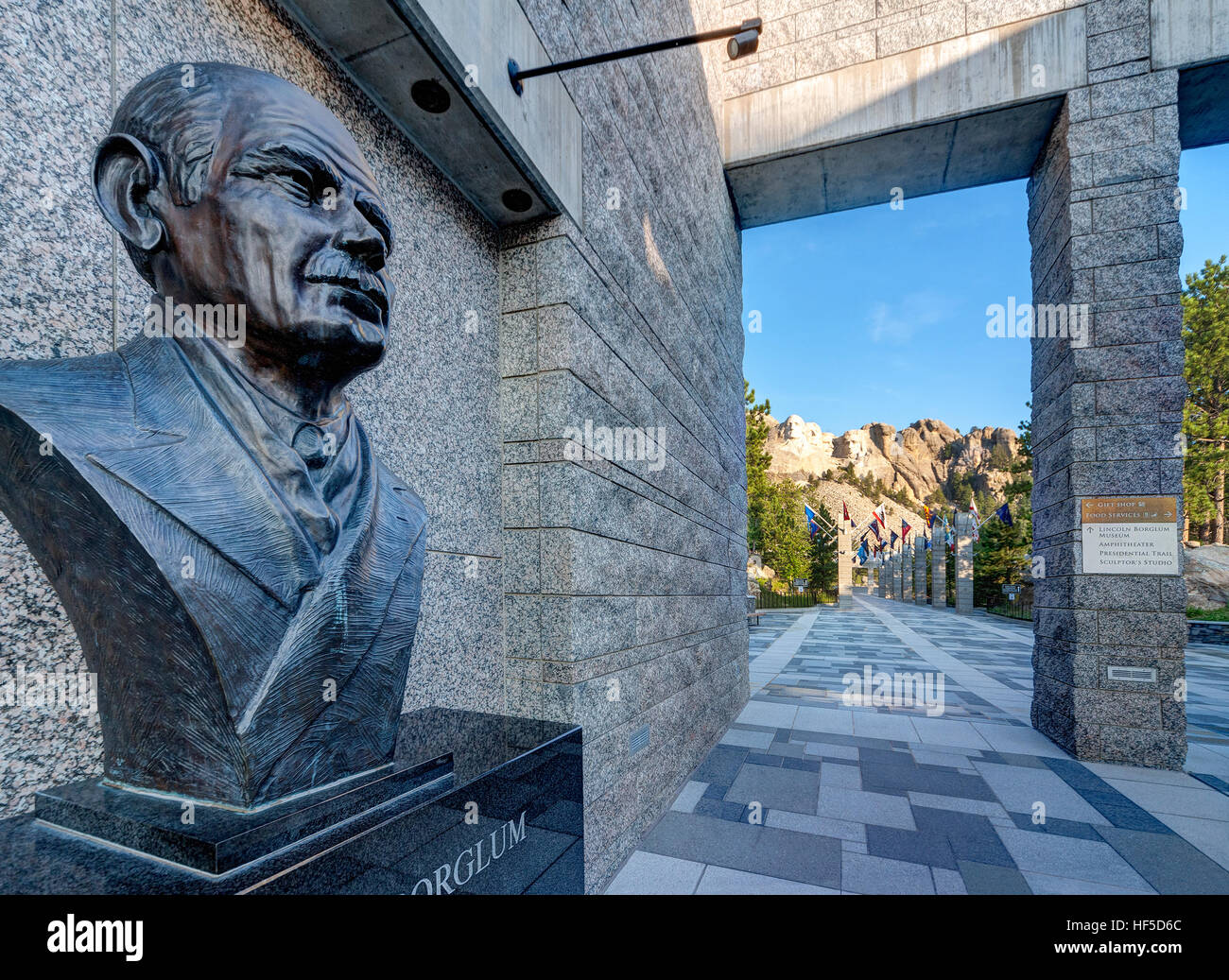 Mount Rushmore National Memorial Visitor Center mit Bildnisbüste der Bildhauer Gutzon Borglum von Mount Rushmore, in der Ferne sichtbar. Stockfoto