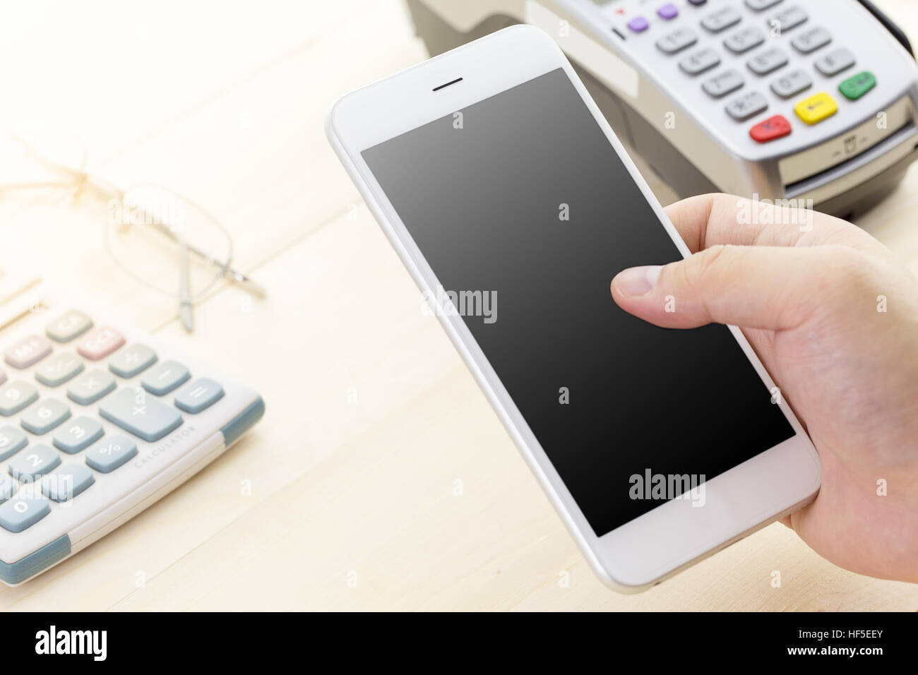 Handgemachte Zahlung mit Kreditkarten-terminal oder EDC mobile Smartphone zu halten. Kunden per Handy mit leeren Bildschirm bezahlen. Stockfoto