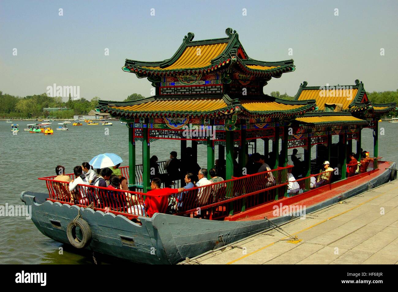 Peking, China - 5. Mai 2005: Ausflugsschiff mit traditionellen glasierten Ziegeldächern auf der See im Park Behei Stockfoto