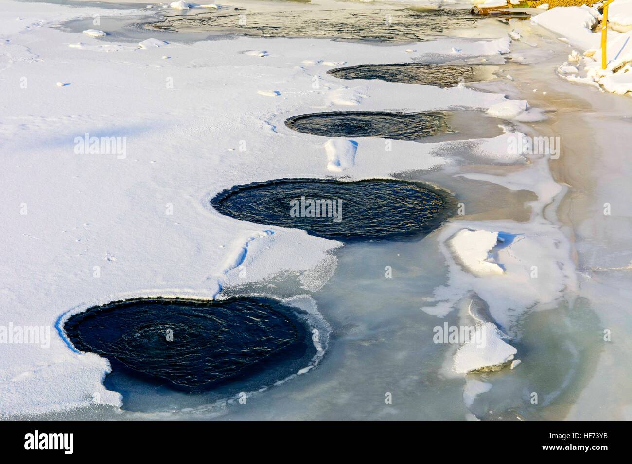 Warmes Wasser auf dem Eis eines gefrorenen Sees im Winter mit Eis bedeckt. Stockfoto