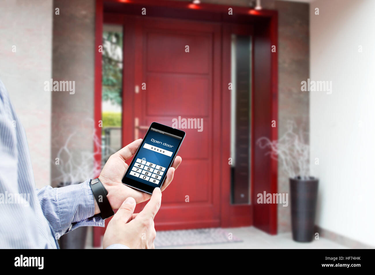 Der Mensch nutzt Smartphone zum Öffnen der Tür seines Hauses Stockfoto