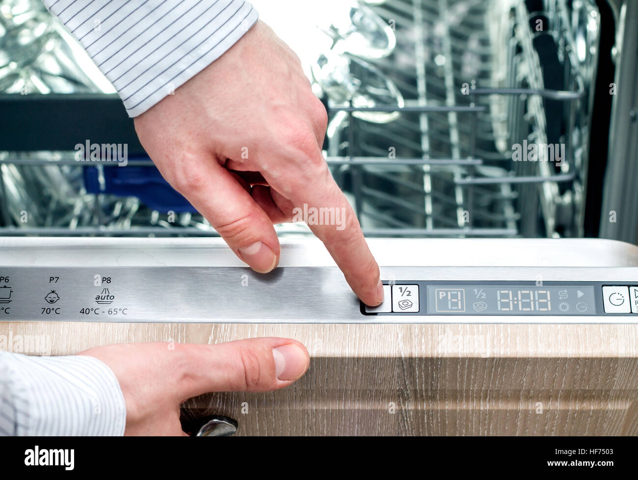 Mann baut ein Programm auf dem Panel des Geschirrspülers Stockfoto