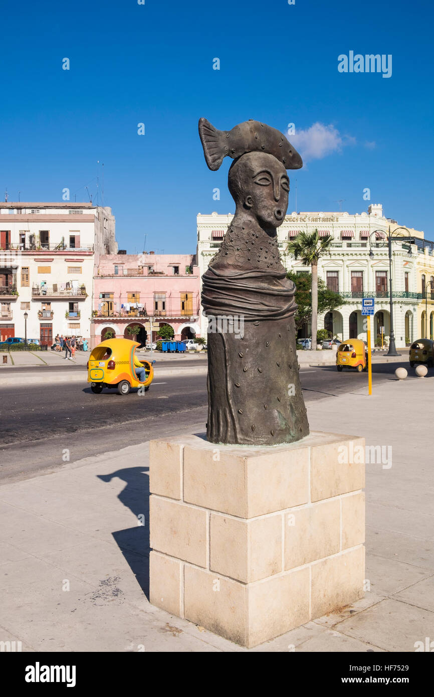 Statue eines Kopfes mit Fisch obenauf, Coco taxis vorbei hinter La Havanna, Kuba. Stockfoto