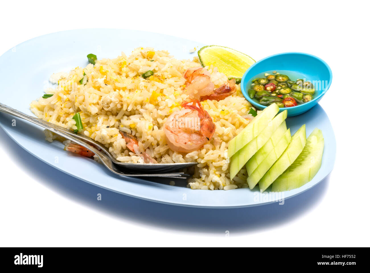 Gebratener Reis mit Ei, in Scheiben geschnittenen Gurken, Chili und Fischsauce in einer blauen Platte auf weißem Hintergrund Stockfoto