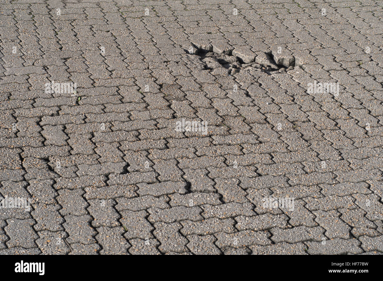 Industrielle Yard/brick road Oberfläche mit Schlagloch. Potenzial für Infrastruktur abstraktes Konzept. Möglich schlechter Verarbeitung Metapher. Stockfoto