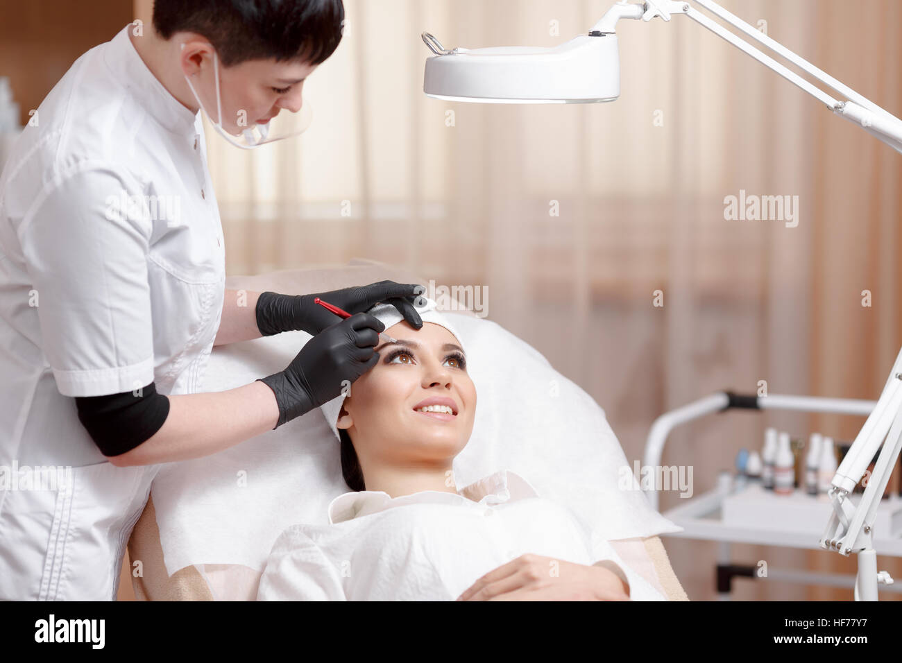 Permanent Make-up-Assistent macht Augenbrauen Korrekturverfahren Stockfoto
