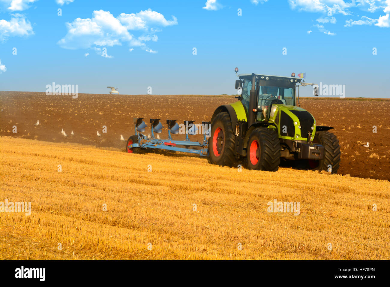 Moderne Landwirtschaft mit Traktor in gepflügtes Feld Stockfoto