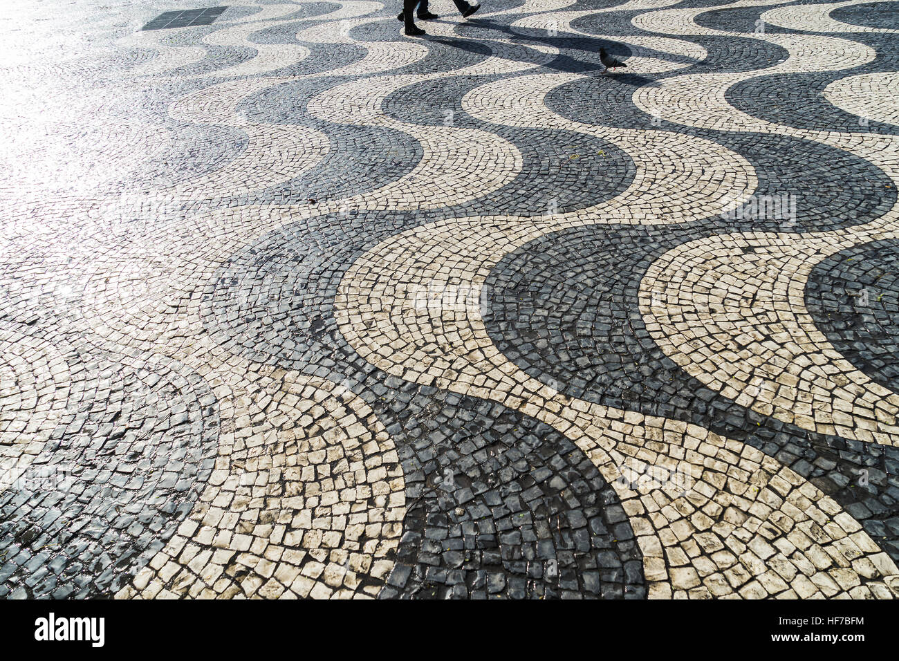 Wenige Menschen wirft einen langen Schatten auf Bürgersteig Stockfoto