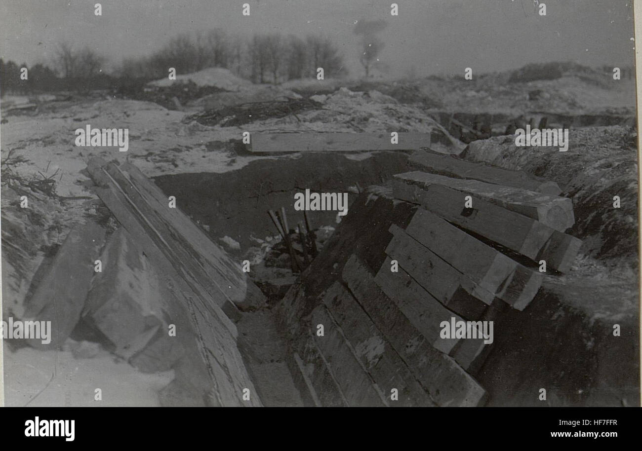 Ein Foto aus deutscher Kriegszeit, das während des Ersten Weltkriegs aufgenommen wurde und Soldaten in einem Graben mit militärischem Material zeigt. Das Bild ist Teil einer Sammlung, die das tägliche Leben und die Not der Soldaten in den Gräben während des Ersten Weltkriegs dokumentiert. Stockfoto