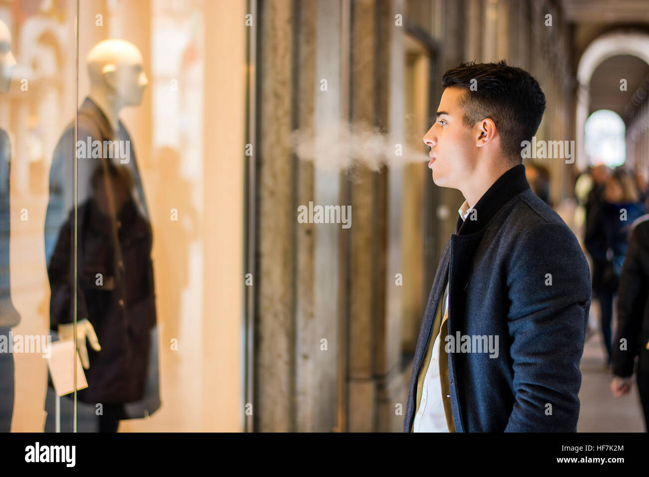 Junger Mann, Blick auf Modeartikel im Schaufenster Stockfoto