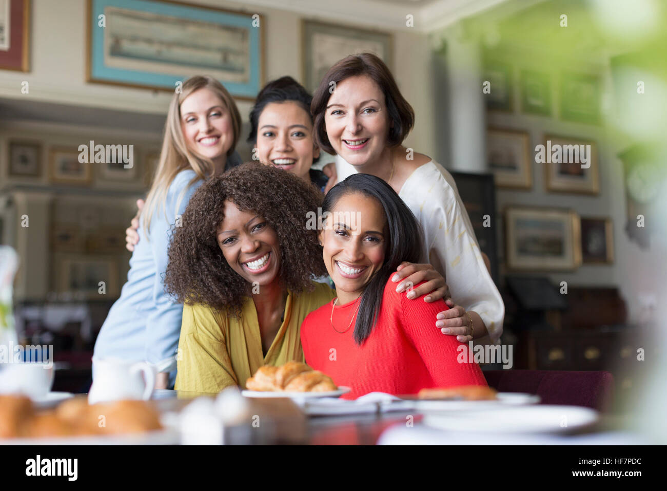 Porträt, Lächeln Frauen Freunde Essen am Tisch im restaurant Stockfoto