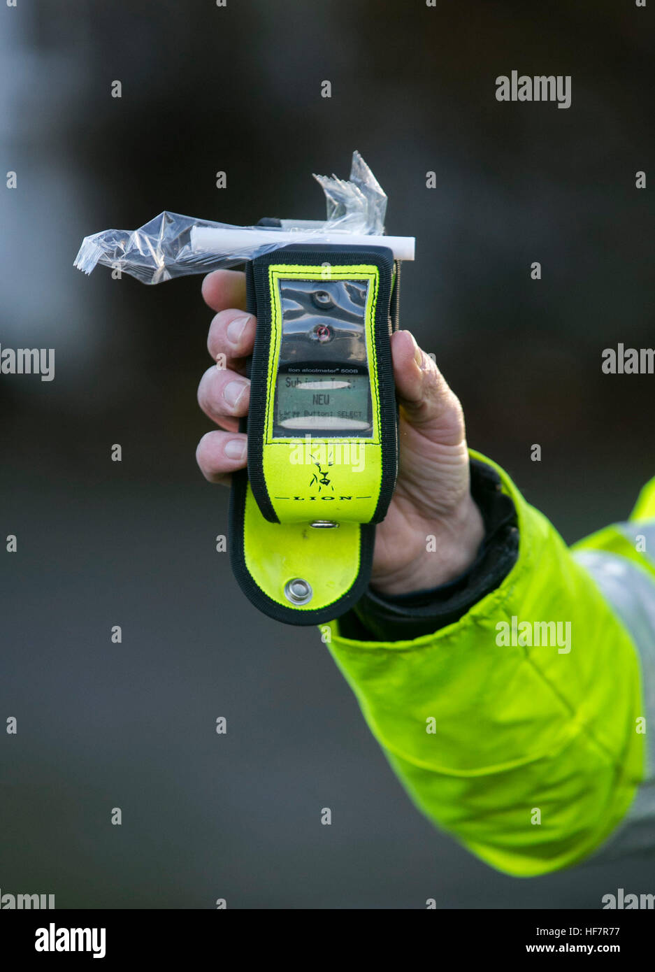 Ein PSNI Straße Polizei-Offizier hält eine operative Alkoholtester während einer zufälligen Alkohol am Steuer-Checkpoint in Belfast. Eine betrunkene Mutter tun die Schule laufen nach eine feuchtfröhliche Mittagessen unter den Hunderten von Fahrern mit neuen Polizeibeamten durchzuführen zufällige Atemtests in Nordirland gefangen war. Stockfoto