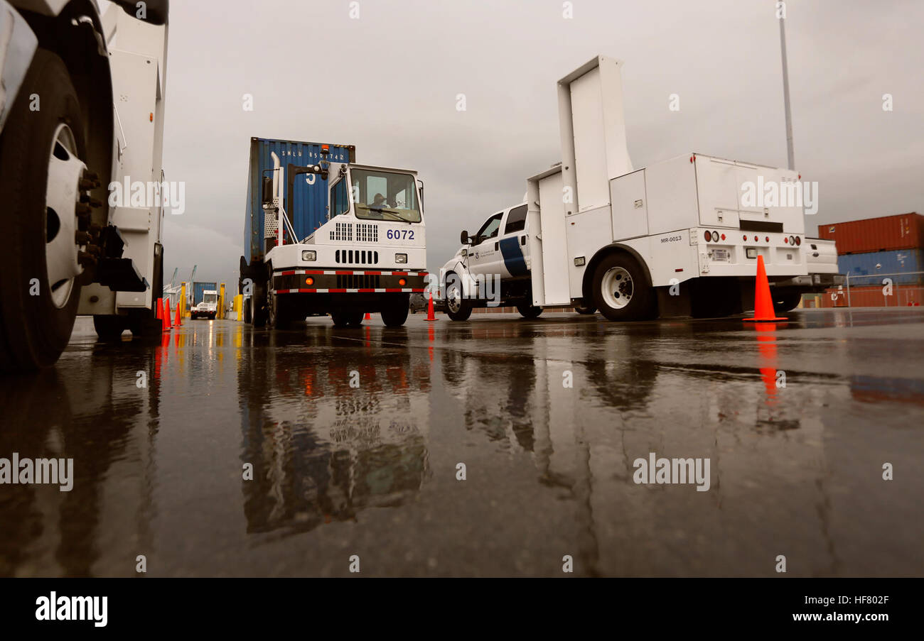 Ein Frachtcontainer, gezogen von einem Port-Fahrzeug wird durch LKW-montierte Strahlung-Detection-Systeme von US Customs and Border Protection Offiziere an der Port of Miami in Miami Florida, 7. Dezember 2015 betrieben gescannt. U.S.  von Glenn Fawcett Stockfoto