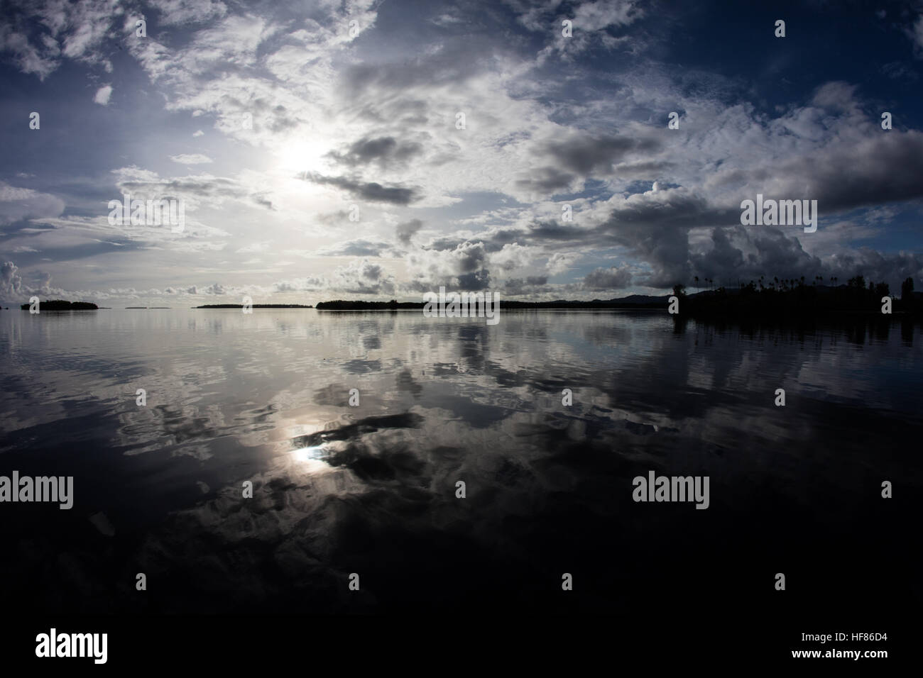 Licht des frühen Morgens fällt auf dem ruhigen Wasser rund um die abgelegenen Inseln auf den Salomonen. Stockfoto