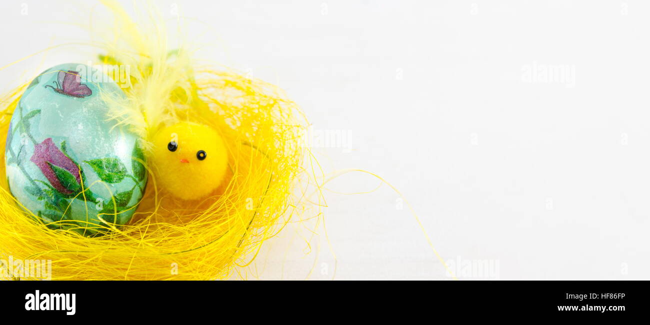 Serviettentechnik dekoriert Osterei in einem gelben nest Stockfoto