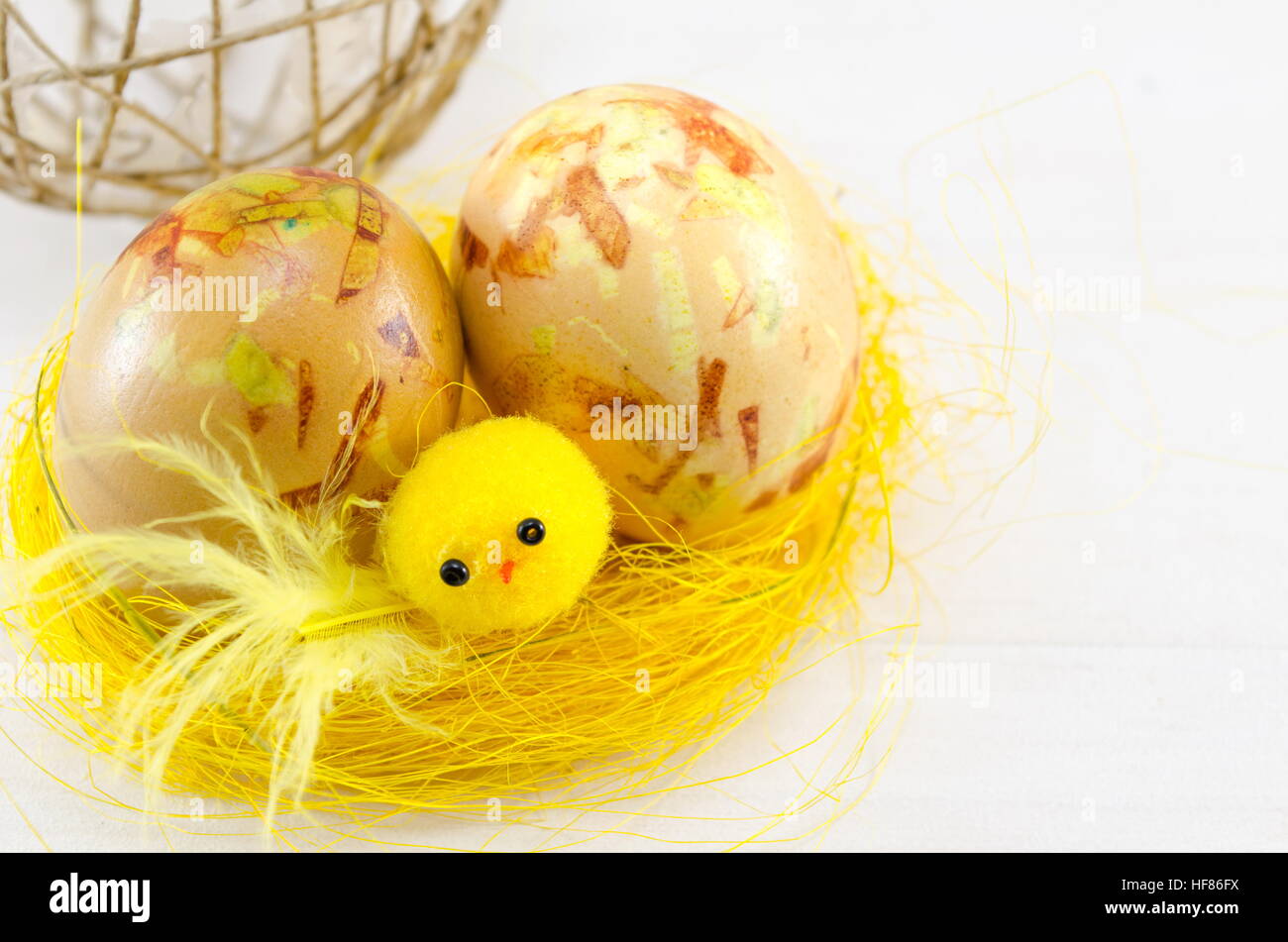 Bemalte Ostereier in einem gelben nest Stockfoto