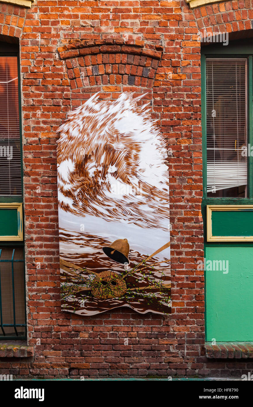 Straßenkunst auf einer roten Backsteinmauer in einer Gasse Stockfoto