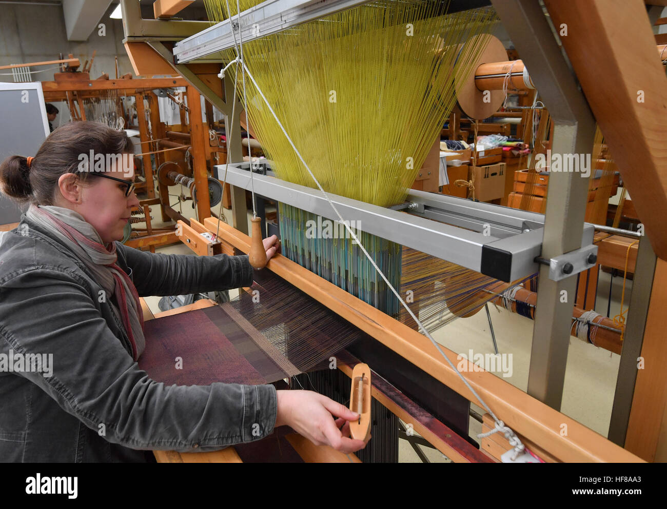 Katharina Stark, Erzieher an der Burg Giebichenstein Hochschule für Kunst und Design Halle, arbeitet an einem Jacquard-Webstuhl in der Werkstatt des Textils produzieren in Halle/Saale, Deutschland, 24. November 2016. Heute ist die traditionelle Textilherstellung, die wodurch Gobelins und Teppichen in der DDR, ein Bildungs- und Forschungsstandort für die Bereiche Malerei und Textilkunst sowie Textil-Design zu studieren, und als solche ist einmalig in Deutschland. Neben Bildung, die Anlage hat auch zwei finanziellen Säulen: Textil-Restaurierung, wie z. B. großen Webereien sowie die Herstellung von Repliken Stockfoto