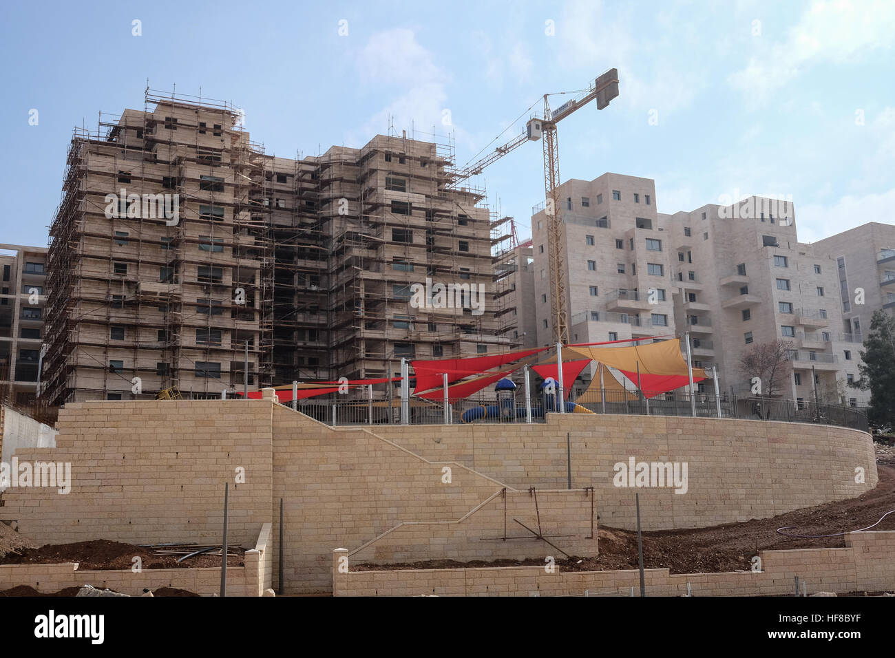 Ost-Jerusalem, Israel. 28. Dezember 2016. Wohnungsbau ist im Gange in Homat Shmuel oder Har Homa in Ost-Jerusalem, auf dem Land enteignet, 1991. Obwohl Israel umstritten, gilt Homat Shmuel eine illegalen israelischen Siedlung von weiten Teilen der Welt. UN-Sicherheitsrat den letzten Auflösung 2334 des 23. Dezember 2016 verurteilt israelische Siedlungen in Ostjerusalem und im Westjordanland, eine Auflösung, die durch US-Enthaltung übergeben. Secretary Of State Kerry wird voraussichtlich seine Vision für die Beendigung des israelisch-palästinensischen Konflikts in einer Rede später heute legen. Stockfoto