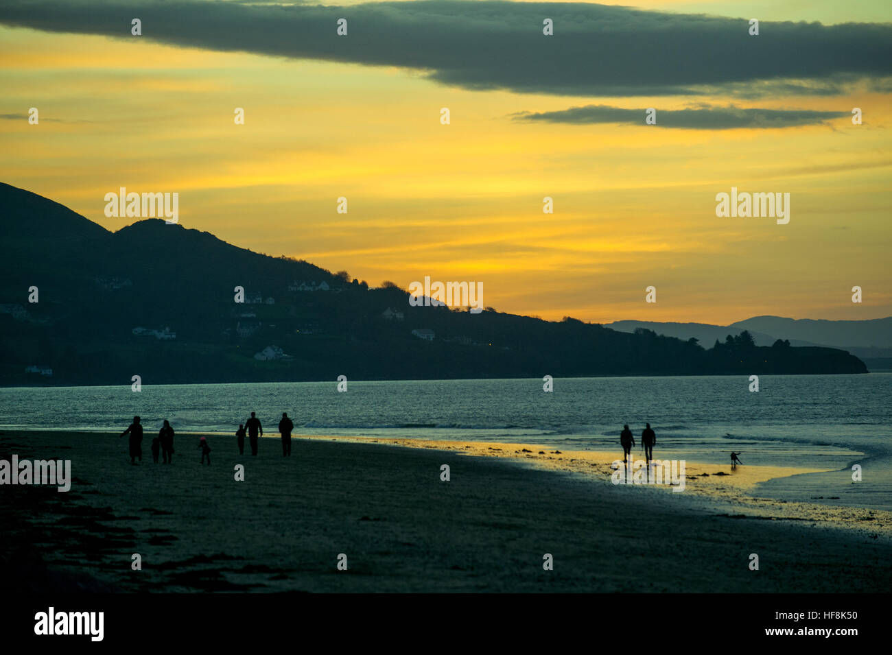 Lough Swilly, Donegal, Irland. 29. Dezember 2016. Irland Wetter: Menschen Spaziergang am Lisfannon Strand, Inishowen, Donegal wie die Sonne über Lough Swilly untergeht. © George Sweeney / Alamy Live News Stockfoto