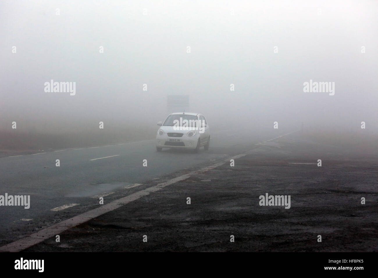 Calderdale, UK. 30. Dezember 2016. Ein Auto ohne Lichter an im Nebel auf Saddleworth, 30. Dezember 2016 (C) Barbara Koch/Alamy Live News Stockfoto