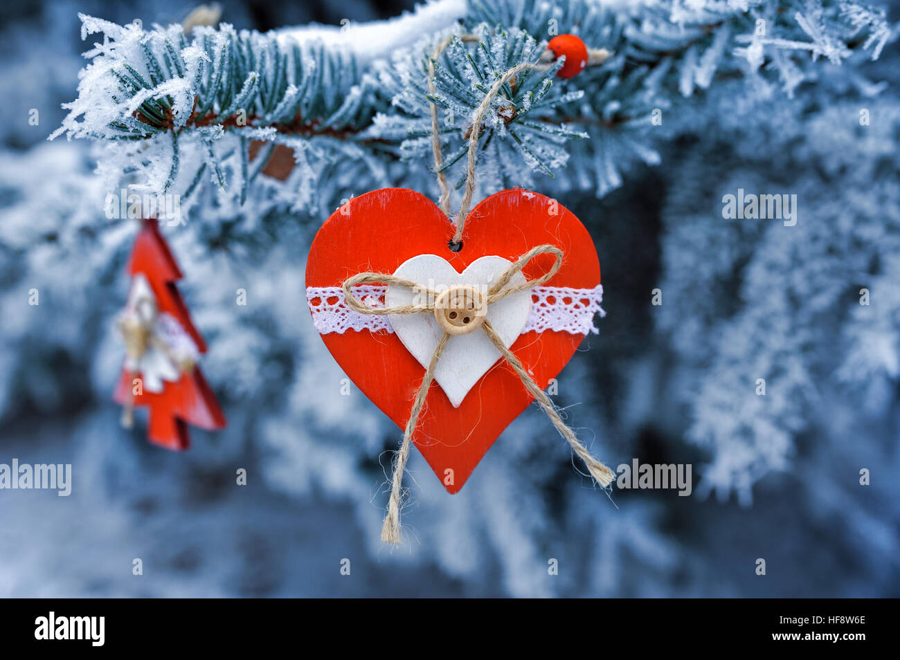 Weihnachten-Holzspielzeug auf einem schönen verschneiten Tannenbaum im winter Stockfoto