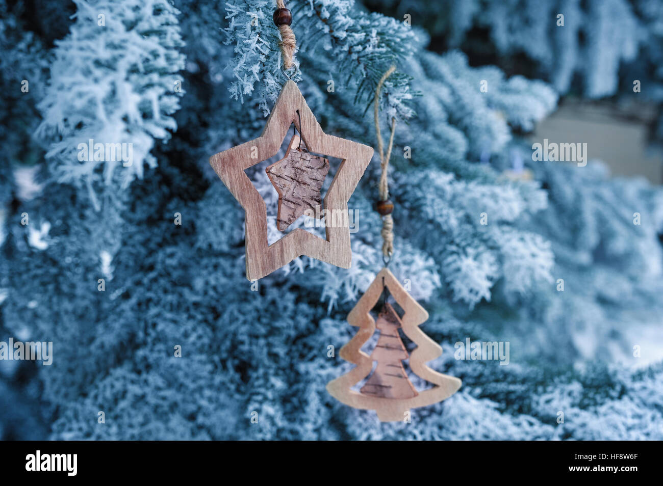 Weihnachten-Holzspielzeug auf einem schönen verschneiten Tannenbaum im winter Stockfoto