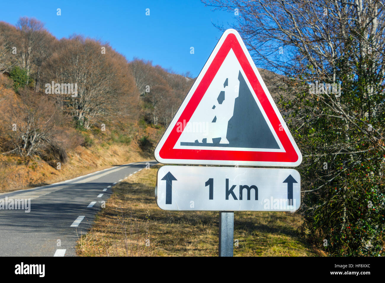 Fallende Felsen 1km dreieckigen Schild mit blauem Himmel Stockfoto