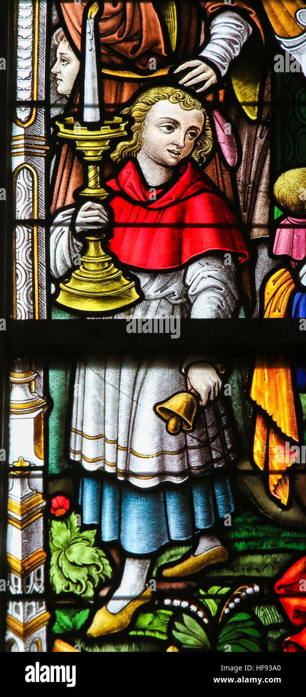 Glasmalerei-Fenster Darstellung Ministrant hält ein Kandelaber in der Kathedrale St. Bavo in Gent, Flandern, Belgien. Stockfoto