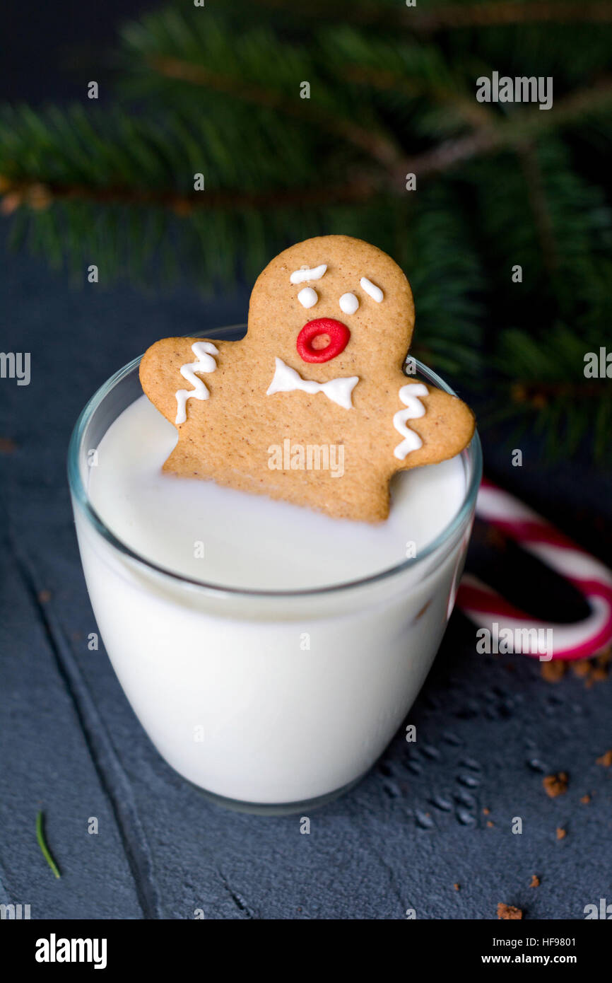 Lebkuchen Mann versinken in einem Glas Milch. Weihnachts-Urlaub-Essen, Winter und Silvester-Konzept Stockfoto