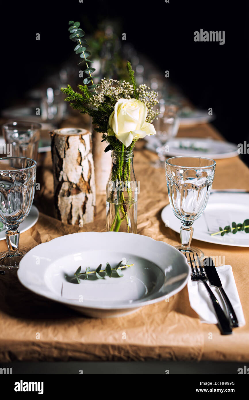 Dekorierten Tisch für das Abendessen bereit. Wunderschön dekoriert Tischset mit Blumen, Kerzen, Teller und Servietten für Hochzeit oder eine andere Veranstaltung im Restaurant. Stockfoto