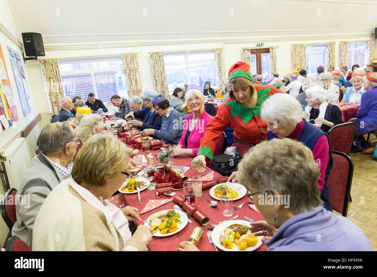 Alte Menschen genießen eine Weihnachtsfeier in der Heiligen Dreifaltigkeit Kirche Hall, Southport Stockfoto