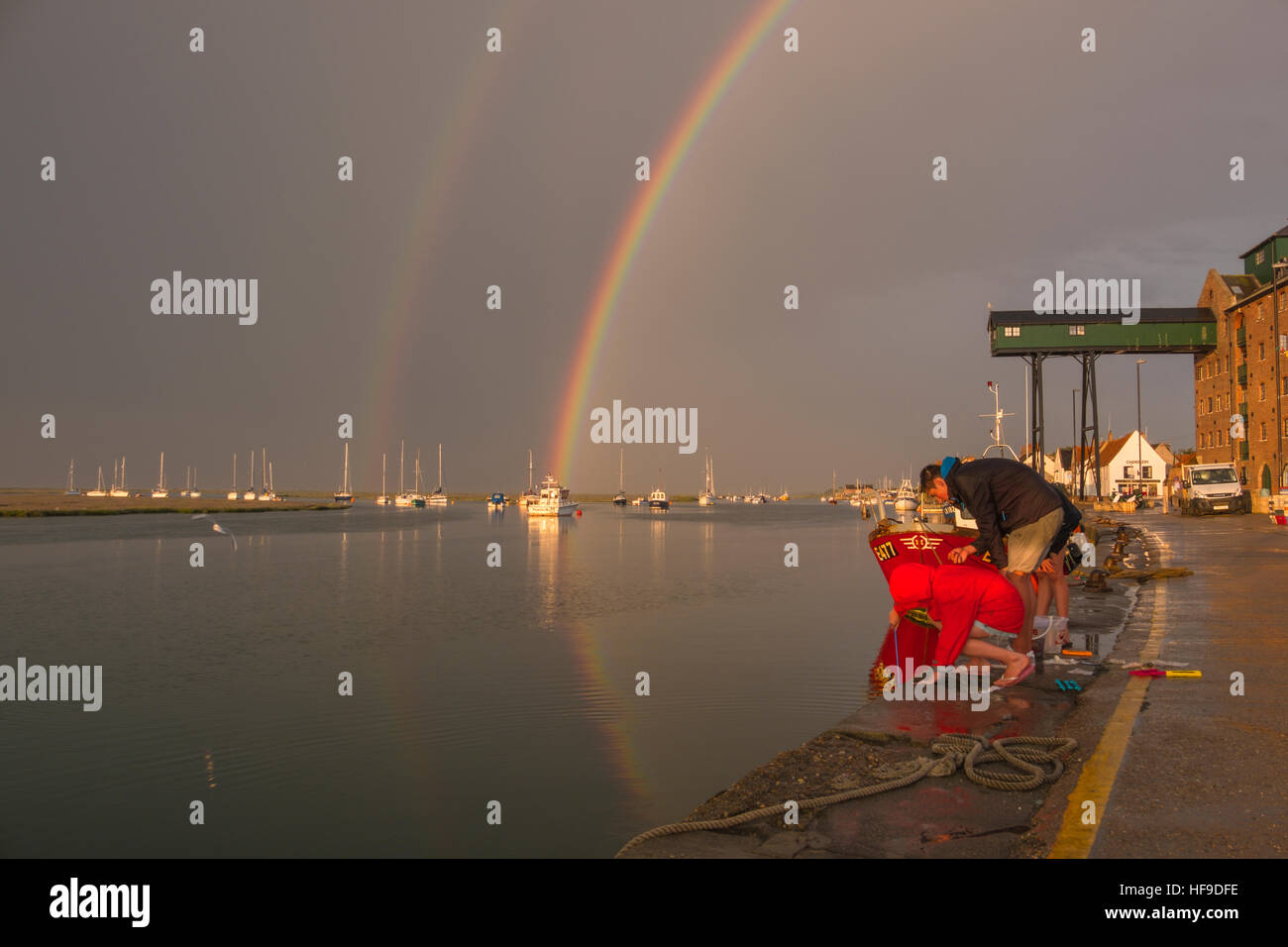 Krabben aus der Hafenmauer als bildet sich ein Regenbogen über Wells-Next-the-Sea bei einem Sommer-Abend-Sturm. Stockfoto