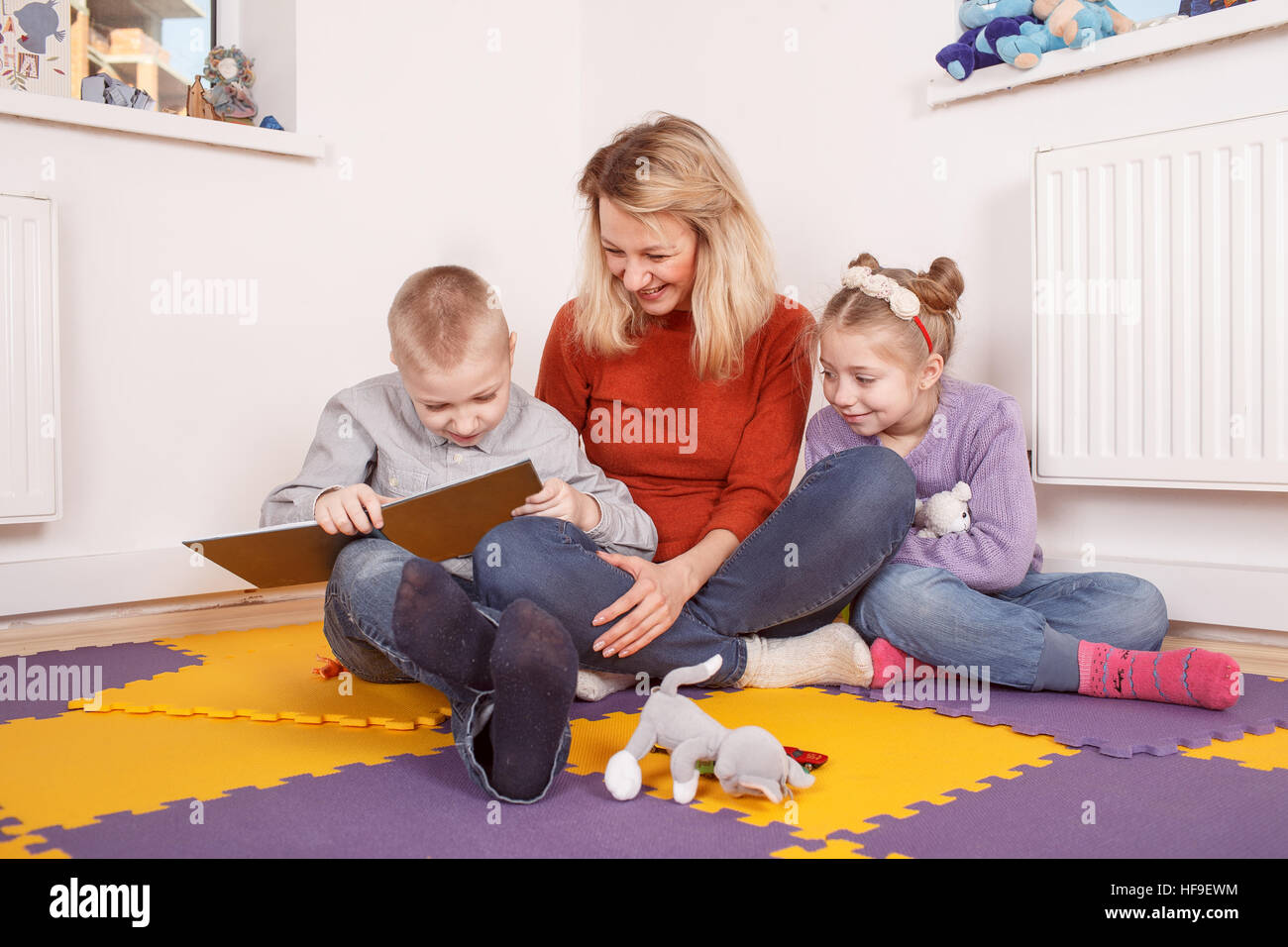 Kinder lesen Märchen mit Upbringer im Kindergarten Stockfoto