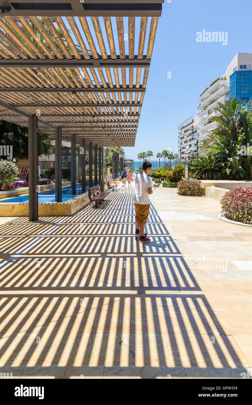 Jugend mit dem Skateboard unter ein Selbstporträt. In Marbella an der Avenida del Mar an einem hellen sonnigen Junitag genommen. Stockfoto