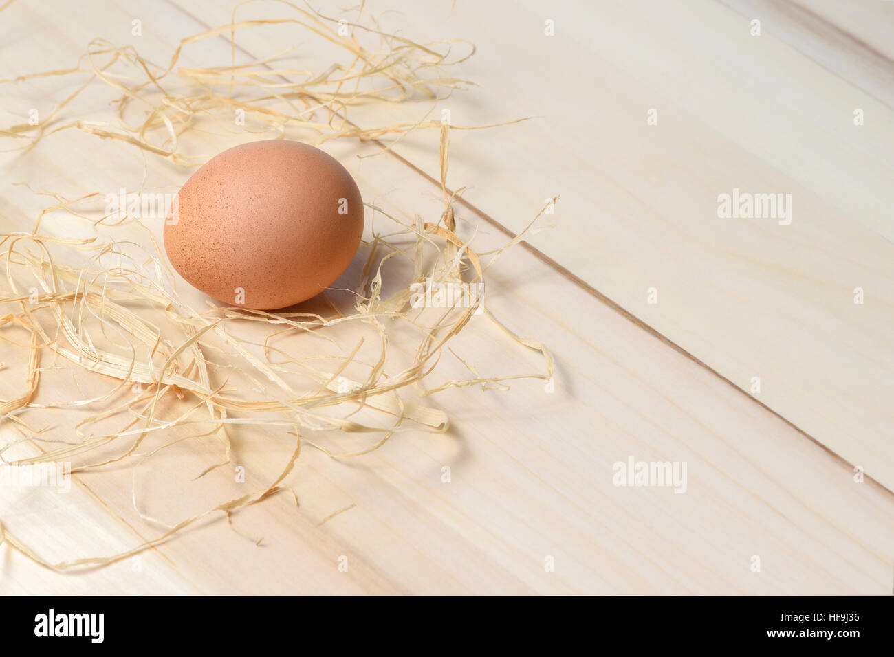 Bio Gefleckte braune Henne Ei auf Holztisch mit Stroh. Stockfoto