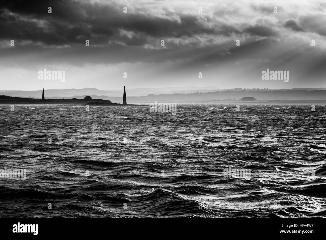 Ansicht von Guile Punkt von Holy Island über die raue See unter Sonnenstrahlen und Wolke Himmel, Northumberland Stockfoto