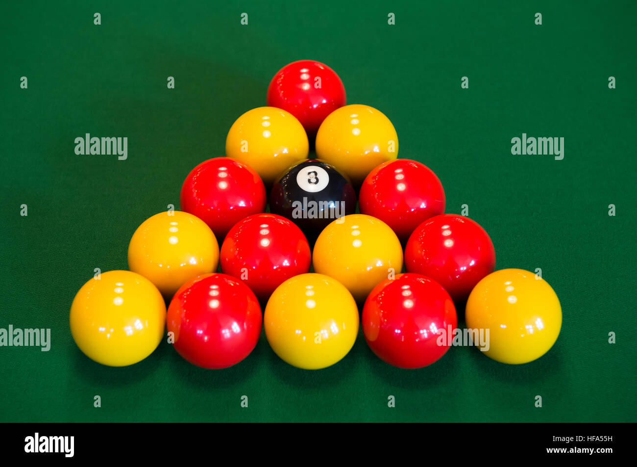 Rote und gelbe Billardkugeln auf dem grünen Tisch. Stockfoto